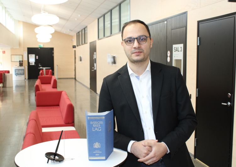 Fuad Heydarov står lutat mot ett bord och har lagboken framför sig