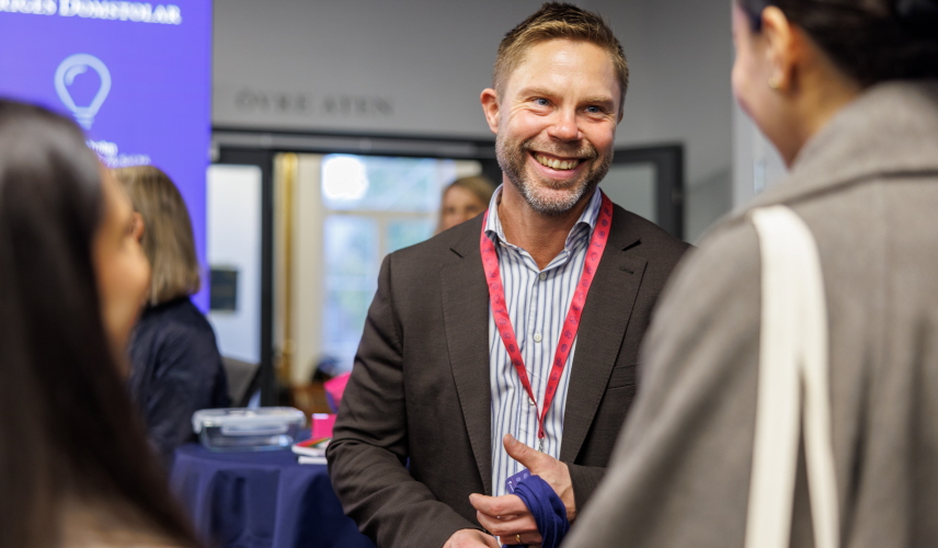 Notarier och studenter i monter på mässa. Foto.